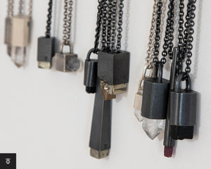Row of raw crystal necklaces with dark metal settings