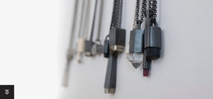 Minimalist Totintor necklaces with raw crystal pendants and dark metal designs on a white background.