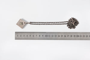 Silver belt with decorative ends and a ruler for scale