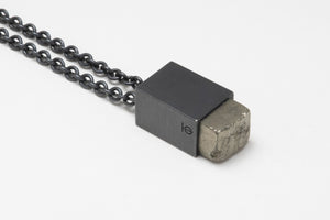Matte black pyrite necklace on white surface